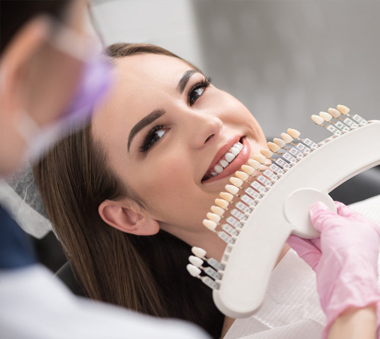 a dentist is testing veneers on a patient's teeth