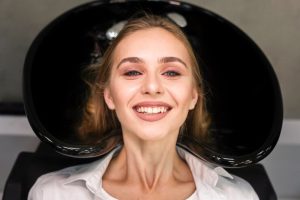 A woman smiling after receiving dental treatment.